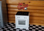 1:12 scale miniature kitchen range in white with 4 burner cooktop and oven, shown on a checkered floor