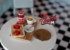 1:12 scale miniature breakfast tray with toast, jam jar and lemon tea on a wood board, shown on a white table with a coin