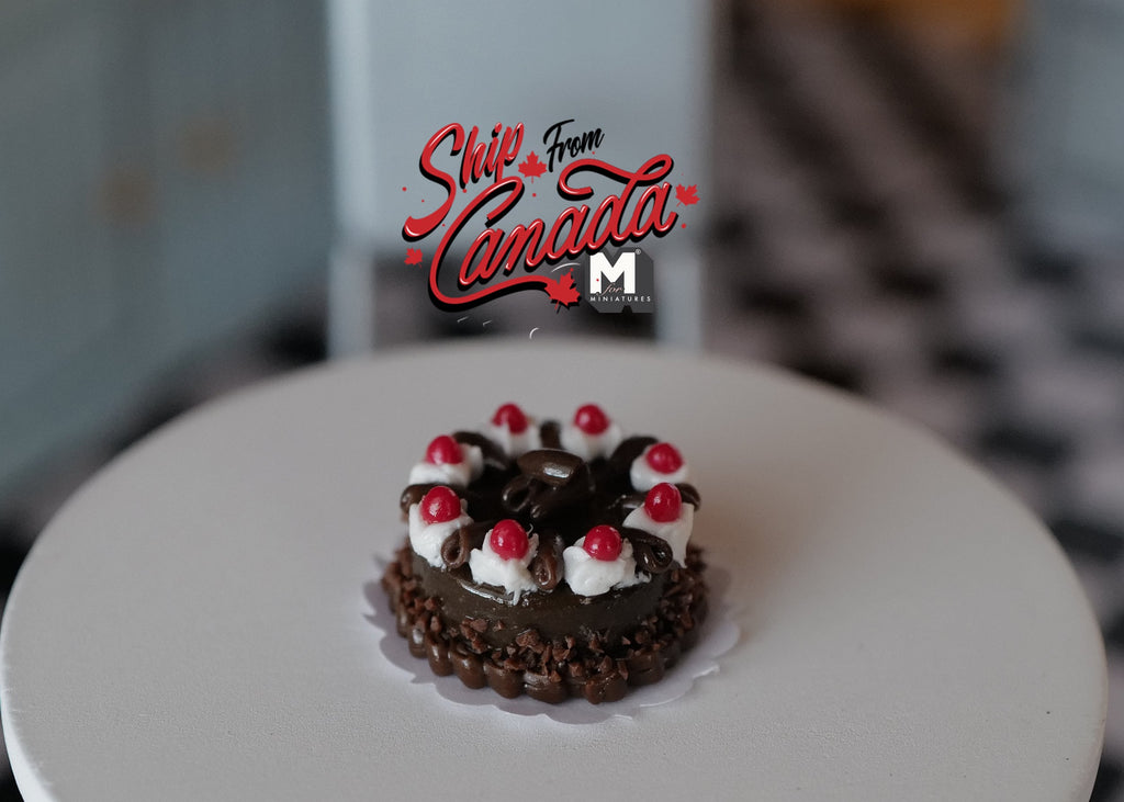 1:12 scale miniature chocolate cherry cake with white cream swirls and red cherries on a doily, on a round white table