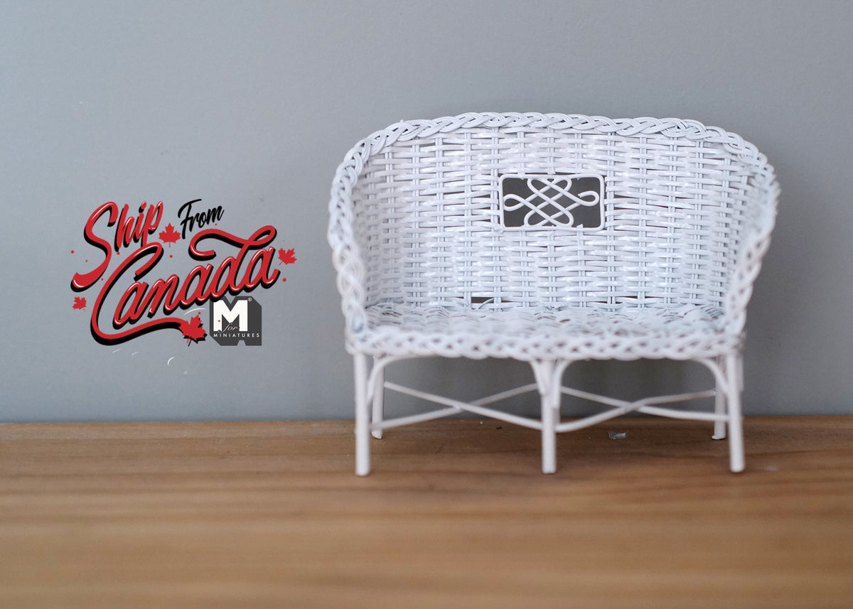 1:12 scale miniature white metal wicker style garden loveseat with a woven curved back, shown on a wood floor