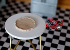 1:12 scale miniature wood round tray with scalloped edge, natural finish, shown on a white side table
