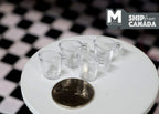 1:12 scale miniature clear measuring cups with handles, set of 4, shown on a white table beside a coin for scale