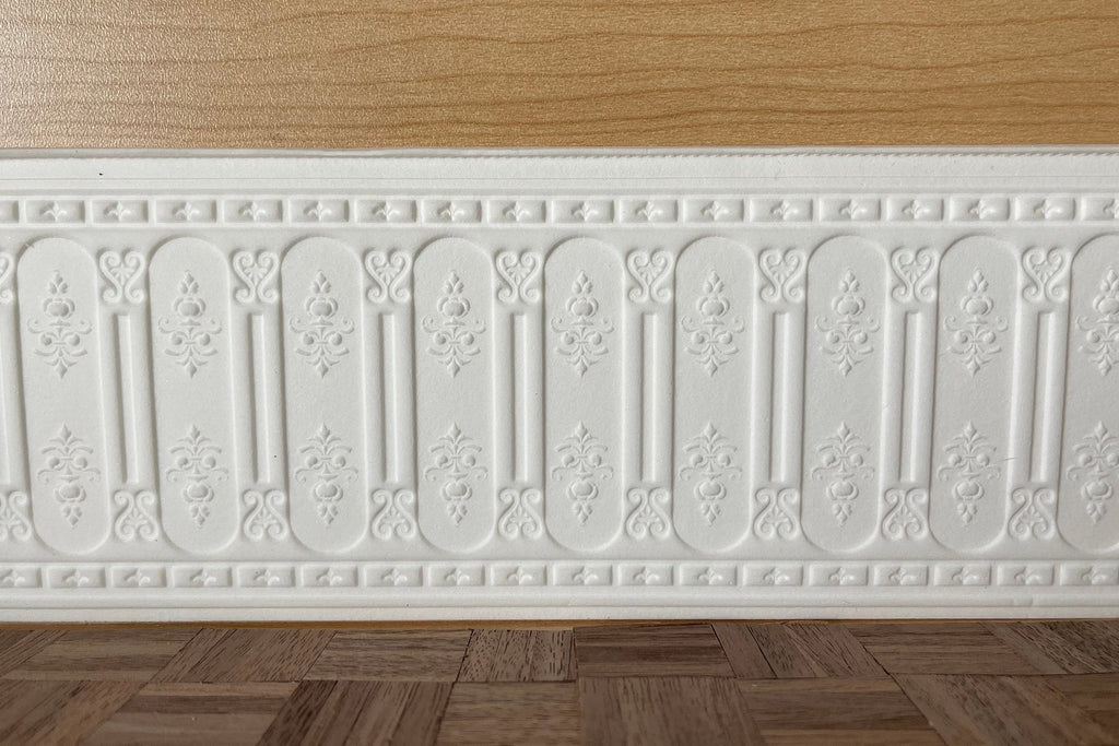 1:12 scale miniature ornate arched panel wainscot in white with embossed arches, shown along a wall above a wood floor