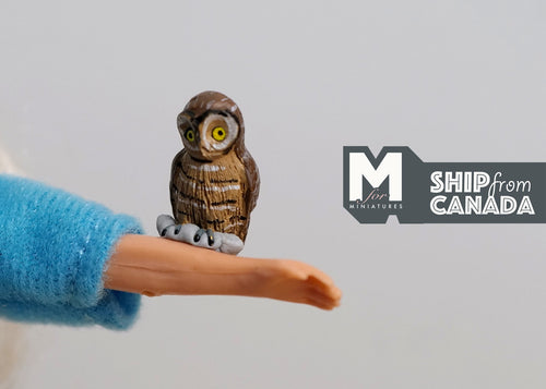 1:12 scale miniature baby owl figurine in brown with yellow eyes, shown perched on a figure's outstretched hand