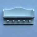 1:12 scale miniature wall shelf in white with 5 pegs and a curved back rail, shown on a blue background