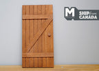 1:12 scale miniature stained wood farmhouse plank door with Z brace, warm brown finish, shown against a gray wall