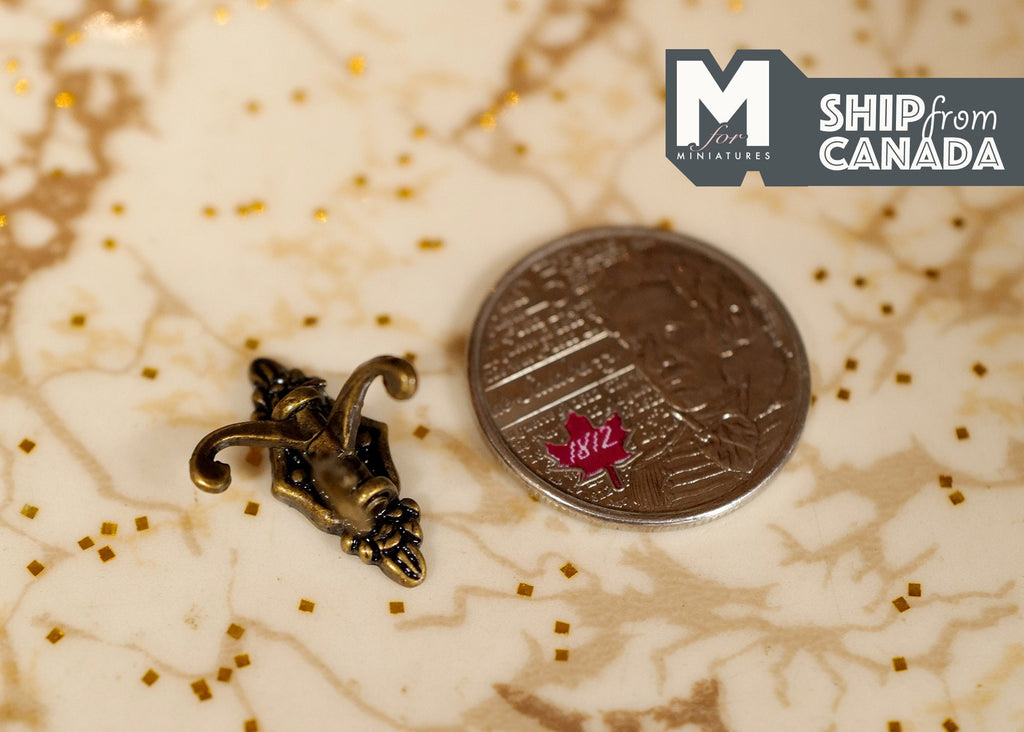 1:12 scale miniature metal triple coat hook in brass with ornate back plate, shown beside a coin for scale