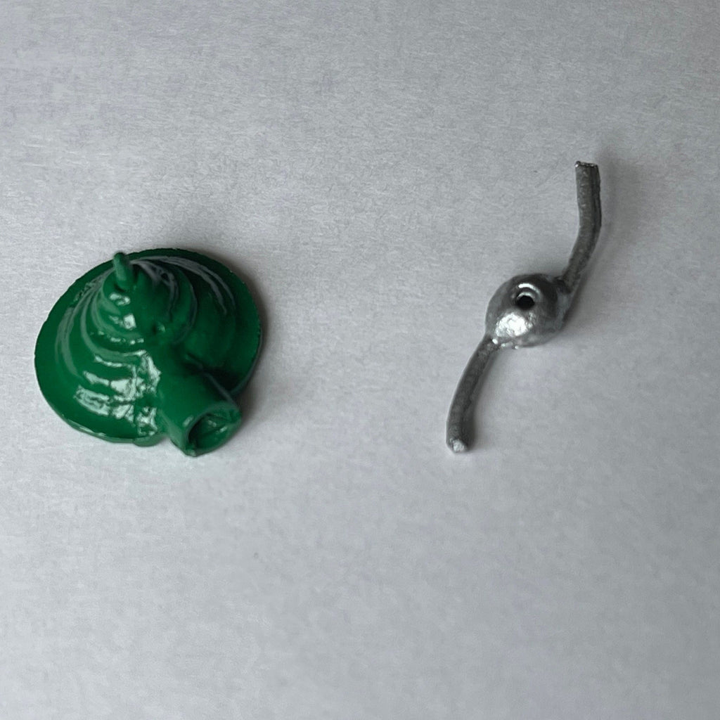 1:12 scale miniature metal rotary garden sprinkler, green dome base and silver spinner arm shown apart on a gray surface