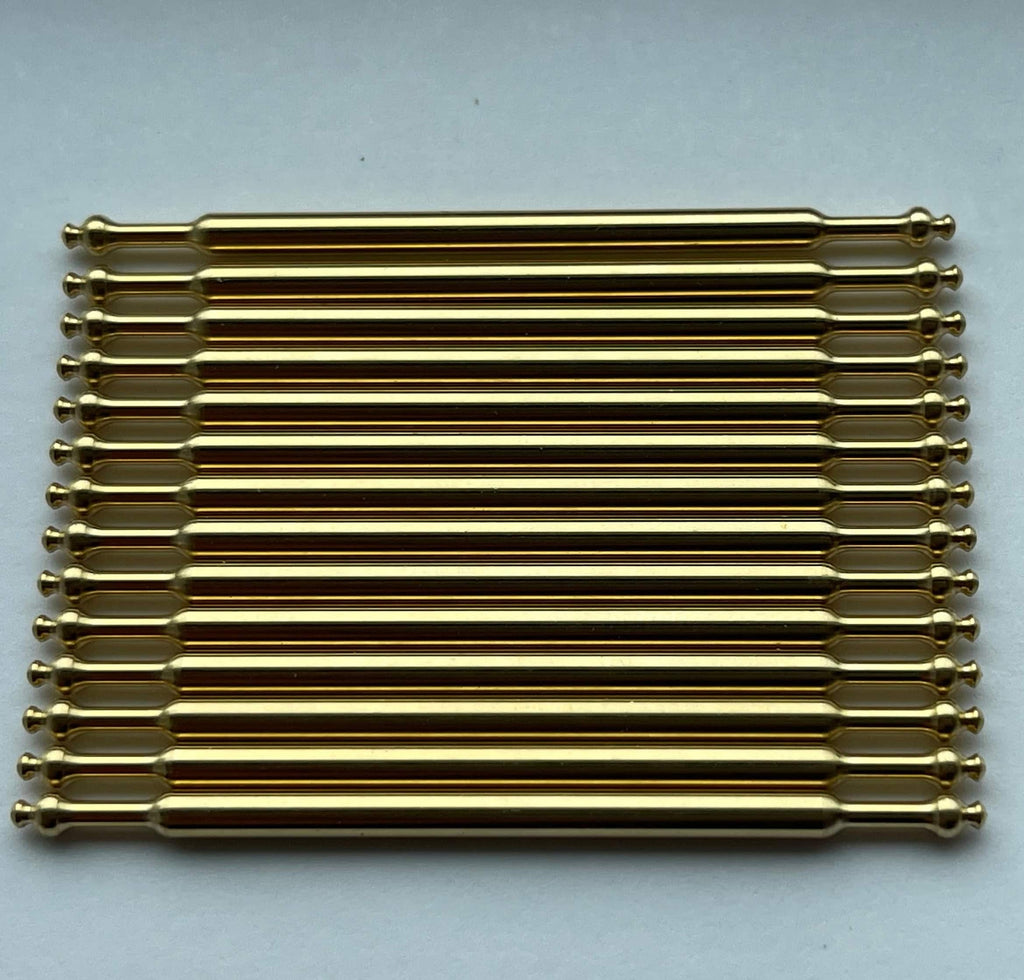 1:12 scale miniature carpet stair rods in antique brass with ball finials, set of 15, laid in a row on a light surface