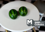 1:12 scale miniature watermelons with dark and light green stripes, set of 2, shown on a round white table