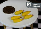 1:12 scale miniature corn cobs, set of 5, yellow corn with husks, shown on a round white table beside a coin