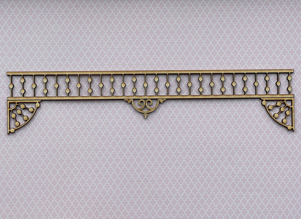 1:12 scale miniature unpainted spool spindle porch trim with scrolled corner brackets, lying on a light background