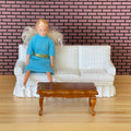 1:12 scale miniature white fabric 3 seat sofa and brown wood coffee table, set of 2, shown with a doll seated on the sofa