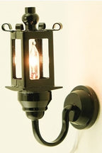 1:12 scale miniature coach wall lamp in black with clear glass panels, 12 volt, shown lit on a cream wall