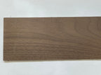 Miniature walnut wood sheet for flooring and walls, dark brown natural grain, thin plank shown on a white surface