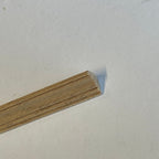 Miniature classic cove wood cornice molding for ceilings, close-up of the unfinished grooved profile end