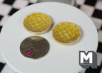 1:12 scale miniature ceramic textured round plates in mustard yellow with a lattice pattern, set of 2, beside a coin