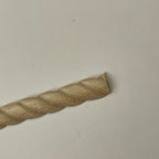 Miniature twisted rope wood baseboard molding for miniature house walls, unfinished, close-up of the carved rope end