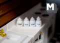 1:12 scale miniature white kitchen canisters with lettered labels for flour, rice, sugar and tea, set of 4, on a counter