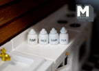 1:12 scale miniature white kitchen canisters with lettered labels for flour, rice, sugar and tea, set of 4, on a counter