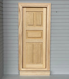 1:12 scale miniature unpainted 5 panel interior door with back trim, shown fitted in a gray sided wall
