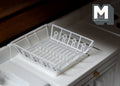 1:12 scale miniature metal dish drainer with mat in white, wire rack with utensil holder, shown on a white kitchen counter