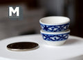 1:12 scale miniature ceramic bowls in blue and white, set of 2, shown stacked on a white table beside a coin