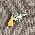 1:12 scale miniature snub nose revolver with tan grip and silver body, non working, shown on gray fabric