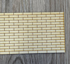 1:12 scale miniature wood brick siding panel, unfinished light wood in a running bond brick pattern, on a gray wood floor