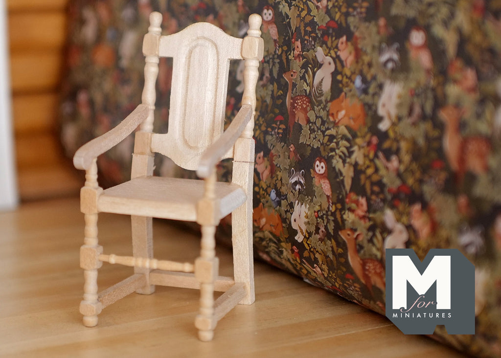 1:12 scale miniature unpainted wood dining chair with tall back and arms, turned legs, shown beside a floral sofa