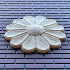 1:12 scale miniature unfinished floral ceiling rose, large, daisy shaped wood medallion shown on a brick surface
