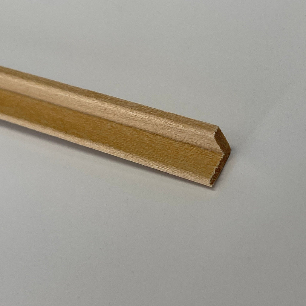 Miniature wood cove cornice molding for ceilings, close view of the angled profile on a natural wood strip