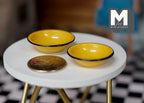 1:12 scale miniature ceramic bowls in yellow with dark rims, set of 2, shown on a round white table beside a coin