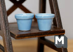 1:12 scale miniature large ceramic round flower pots in light blue, set of 2, shown on a dark wood plant stand