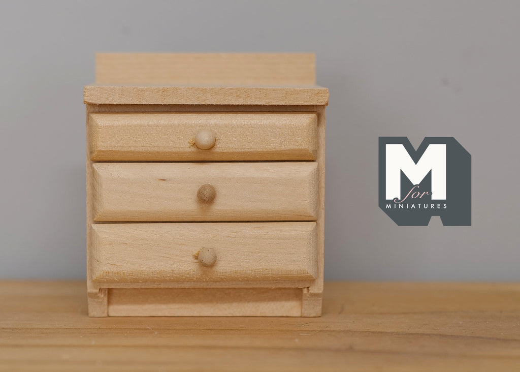 1:12 scale miniature unpainted wood nightstand with 3 drawers and round knobs, shown against a gray wall