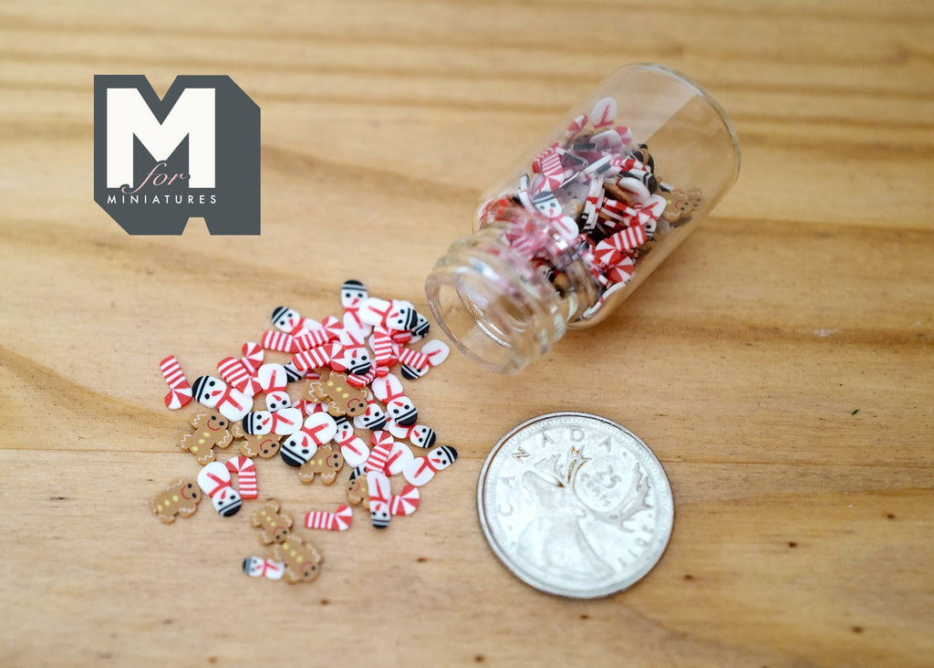 1:12 scale miniature glass candy jar with red, white and green Christmas candies spilling out, shown beside a coin