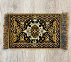 1:12 scale miniature black and gold wool medallion area rug with fringe, geometric border, shown on a wood floor