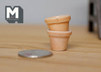 1:12 scale miniature round clay flower pots in terracotta, set of 2, shown stacked on a wood surface beside a coin