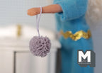 1:12 scale miniature bath sponge pouf with loop in mauve gray, shown hanging from a doll's hand