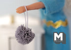 1:12 scale miniature bath sponge pouf with loop in cool gray, shown hanging from a doll's hand