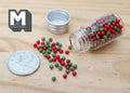 1:12 scale miniature Christmas ball beads kit in red and green, glass jar with lid, shown spilled beside a coin