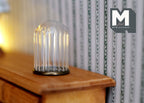 1:12 scale miniature fluted glass dome display with a round black base, shown on a wood dresser