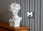 1:12 scale miniature classical bust sculpture in white with curly hair on a square base, shown on a wood dresser