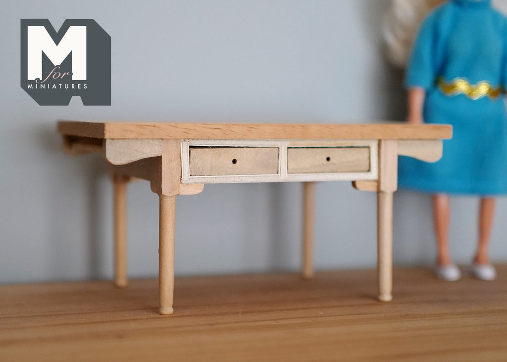 1:12 scale miniature unpainted wood table with 2 drawers and slim tapered legs, shown beside a doll in a blue dress