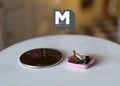 1:12 scale miniature chocolate brownies in a pink dish, shown beside a coin for scale on a white table