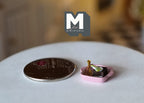 1:12 scale miniature chocolate brownies in a pink dish, shown beside a coin for scale on a white table