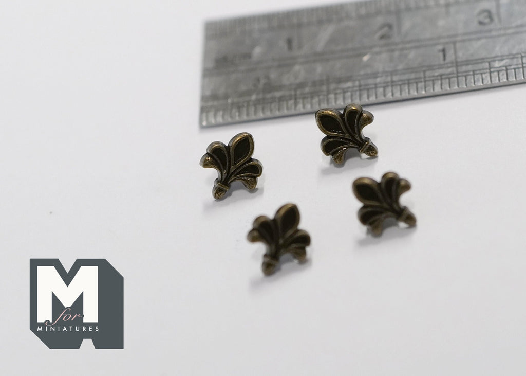 1:12 scale miniature antique brass fleur de lis cabinet knobs, set of 4, shown on a white surface with a ruler