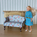 1:12 scale miniature upholstered Lawson sofa, 2 seat, light blue floral print with pink roses, shown beside a figure
