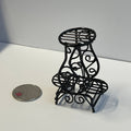 1:12 scale miniature black metal wire plant stand, 2 tier scroll design for 3 pots, shown beside a coin for scale