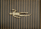 1:12 scale miniature black and tan harlequin diamond peel and stick flooring paper, shown with a wooden artist figure